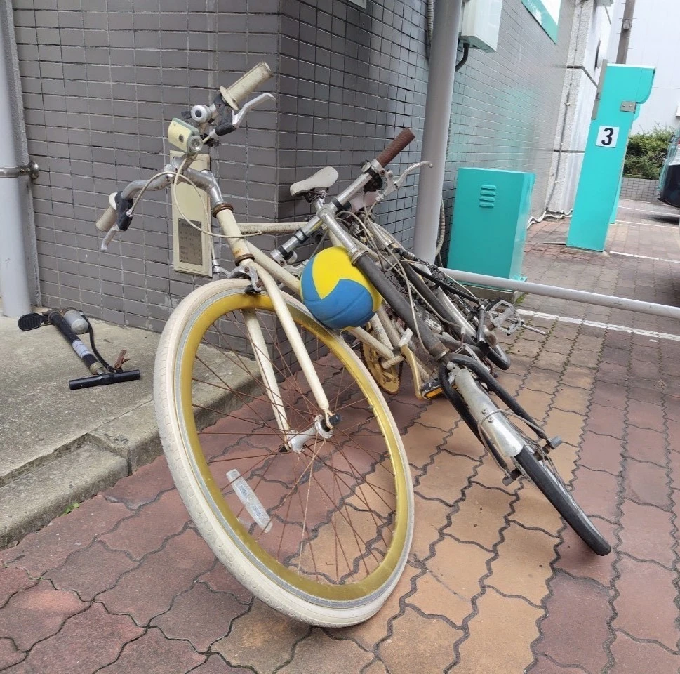 二台の古い自転車の間にバレーボールが挟まれている。
